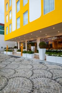 a yellow building with a stone floor in front of a building at Bloom Hub - ORR Marathahalli in Bangalore