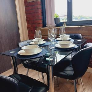 uma mesa preta com pratos e copos de vinho em Bliss Apartments - Contractor 301 em Bradford