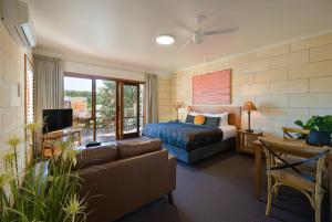 una camera d'albergo con letto e divano di Loch Ard Motor Inn a Port Campbell