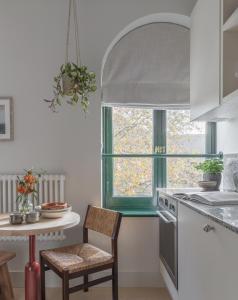 a kitchen with a table and a chair and a window at Mason & Fifth, Bermondsey in London