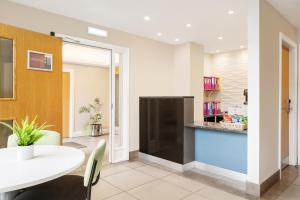 a kitchen and dining room with a white table and chairs at Rooms Inn in Newcastle upon Tyne