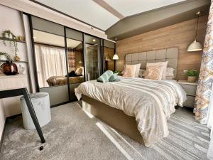 ein Schlafzimmer mit einem großen Bett in einem Zimmer in der Unterkunft Oakland Lodge with Hot Tub and free parking in York