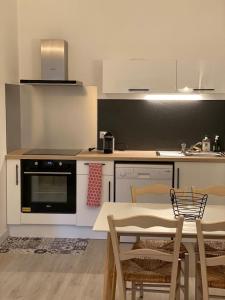 a kitchen with a table and chairs and a stove at Appartement Cosy avec vue sur le château in Chinon
