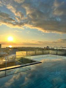 uma piscina no telhado de um edifício com o pôr do sol em PHÚ YÊN EVERYDAY HOTEL em Tuy Hoa