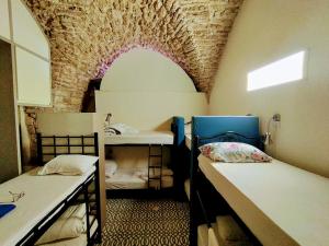 a room with two bunk beds and a brick wall at PoliHosts Old Jaffa in Tel Aviv