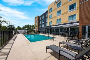 una piscina en un hotel con bancos y mesas en Fairfield Inn & Suites Brooksville Suncoast Parkway, en Brooksville
