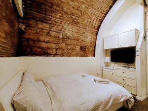 una camera con letto, TV e muro di mattoni di PoliHosts Old Jaffa a Tel Aviv