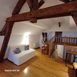 a living room with a white couch and a wooden floor at Esterline in Hautvillers