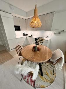 uma cozinha com uma mesa de madeira e 2 cadeiras em 2 Room / Central Railway / Free parking / Sauna em Oulu