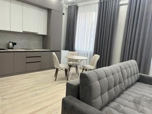 een woonkamer met een bank en een tafel bij Квартира в Актау 362 in Aqtau