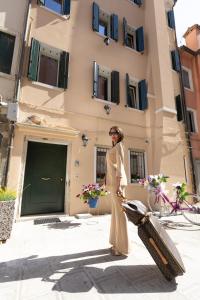 une femme debout devant un bâtiment dans l'établissement B&B LUXURY SUITE ANTONIETTA, à Chioggia