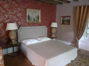 a bedroom with a white bed and two lamps at Le CLOS BOURBON in Ferrières-sur-Sichon