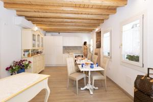 - une cuisine et une salle à manger avec une table et des chaises dans l'établissement B&B LUXURY SUITE ANTONIETTA, à Chioggia