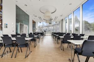 una sala de conferencias con mesas, sillas y ventanas grandes en Clarion Hotel Trondheim, en Trondheim