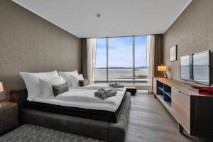 a bedroom with a large bed and a large window at Clarion Hotel Trondheim in Trondheim