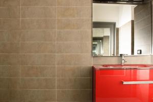 baño con lavabo rojo y espejo en B&D Dolce Vita, en Roma