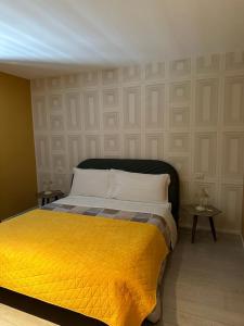 - une chambre avec un lit et une couverture jaune dans l'établissement Rosso Segnale Milano, à Milan