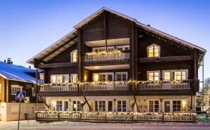 a large wooden building with lights on it at Levillenet Glacier Alpine Chalets at Levi Centre in Levi