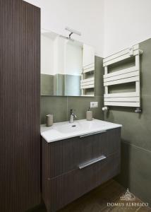 ein Badezimmer mit Waschbecken und Spiegel in der Unterkunft Domus Alberico 11 (Vaticano) in Rom