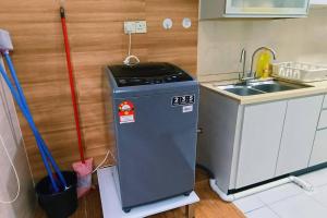 una cocina con lavadora junto a un fregadero en kulai2story 5R24pax nearJPO/JB airport ioiMall Aeon, en Kulai
