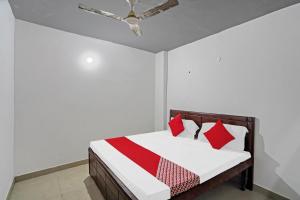 a bedroom with a bed with red pillows and a ceiling fan at OYO Sunrise Villa Near Select Citywalk Mall in New Delhi