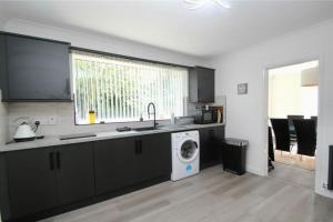 a kitchen with a sink and a washing machine at Full Modern Home - short & long stays 