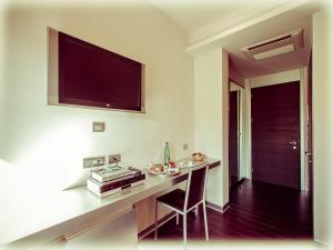 a kitchen with a table and a television on the wall at All Ways Garden Hotel & Leisure in Castel di Leva
