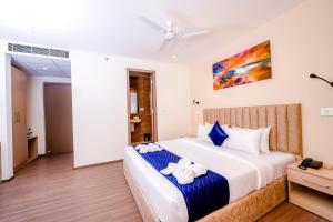 um quarto com uma cama grande e toalhas em Casa Hotel & Suites, Gachibowli, Hyderabad em Hyderabad