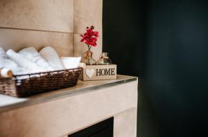 ein Badezimmer mit Körben mit Handtüchern und einem Home-Schild in der Unterkunft Sunset Stodoły w Bieszczadach in Ustrzyki Dolne
