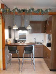 eine Küche mit zwei Barhockern und einem Waschbecken in der Unterkunft Casa María, ático con vistas y parking in Sant Joan de les Abadesses