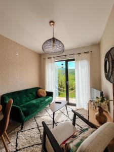 a living room with a green couch and a window at Elysian Fields - Tiny House 'Evergreen' in Sadu