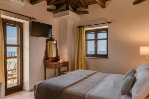 a bedroom with a bed and a window at Eleonas Houses - Kardamili's Acqua Bliss in Kardamyli