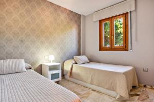 a bedroom with two beds and a window at Ático Novo Sancti in Chiclana de la Frontera +18 photos
