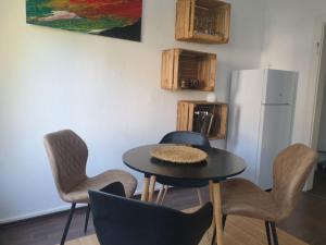 uma cozinha com uma mesa e cadeiras e um frigorífico em Schöne Wohnungen in Essen em Essen