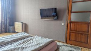 um quarto com uma cama e uma televisão na parede em Двухкомнатная Квартира на Пятницкой em Chernigov