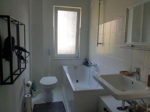 La salle de bains est pourvue d'un lavabo, de toilettes et d'une baignoire. dans l'établissement Schöne Wohnungen in Essen, à Essen
