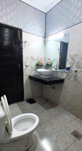 uma casa de banho com um lavatório, um WC e um espelho. em Islamabad 430 B&B Hotel em Islamabad