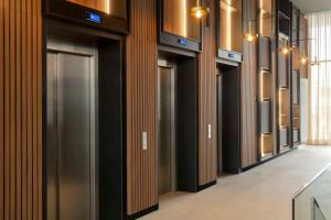 une rangée de portes d'ascenseur dans un bâtiment dans l'établissement NH Iquique Pacifico, à Iquique