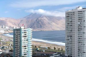 a view of a mountain and a beach and two buildings at NH Iquique Pacifico in Iquique