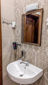 a bathroom with a white sink and a mirror at Двухкомнатная Квартира на Пятницкой in Chernihiv