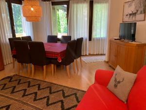 een woonkamer met een eettafel en stoelen bij SPINALE casa in centro, arrivi con gli sci! SANIFICAZIONE A VAPORE in Madonna di Campiglio