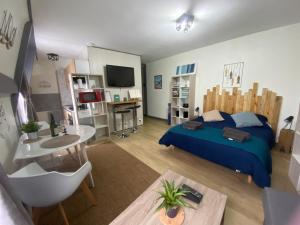 een slaapkamer met een bed en een bureau met een televisie bij Le cocon sainte Catherine in Honfleur
