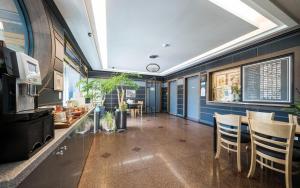 Hotel New Evergreen في موكبو: غرفة طعام بجدران زرقاء وكراسي خشبية