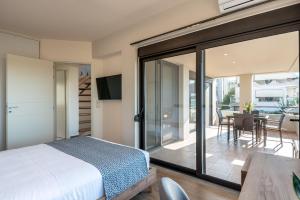 a bedroom with a bed and a sliding glass door at Phaedra by PosarelliVillas in Kounoupidhianá