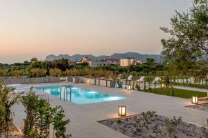 a swimming pool with chairs and a resort at Phaedra by PosarelliVillas in Kounoupidhianá