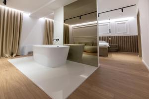 een badkamer met een wit bad en een slaapkamer bij Hotel IN in Žepče