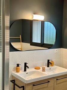 La salle de bains est pourvue d'un lavabo et d'un miroir. dans l'établissement La Halte Occitane - Logement neuf 6 personnes 3 chambres tout confort, à Montauban
