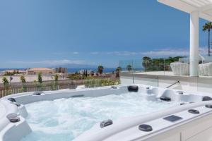 eine Whirlpool-Badewanne auf dem Balkon mit Aussicht in der Unterkunft KARAT Villa Royal White in Adeje