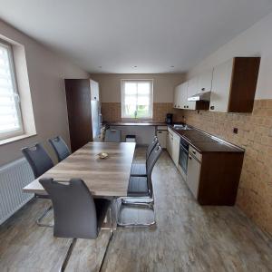 an empty kitchen with a wooden table and chairs at Wolfi in Sankt Wendel