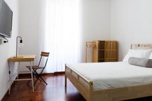 a bedroom with a bed and a desk and a television at B&D Dolce Vita in Rome